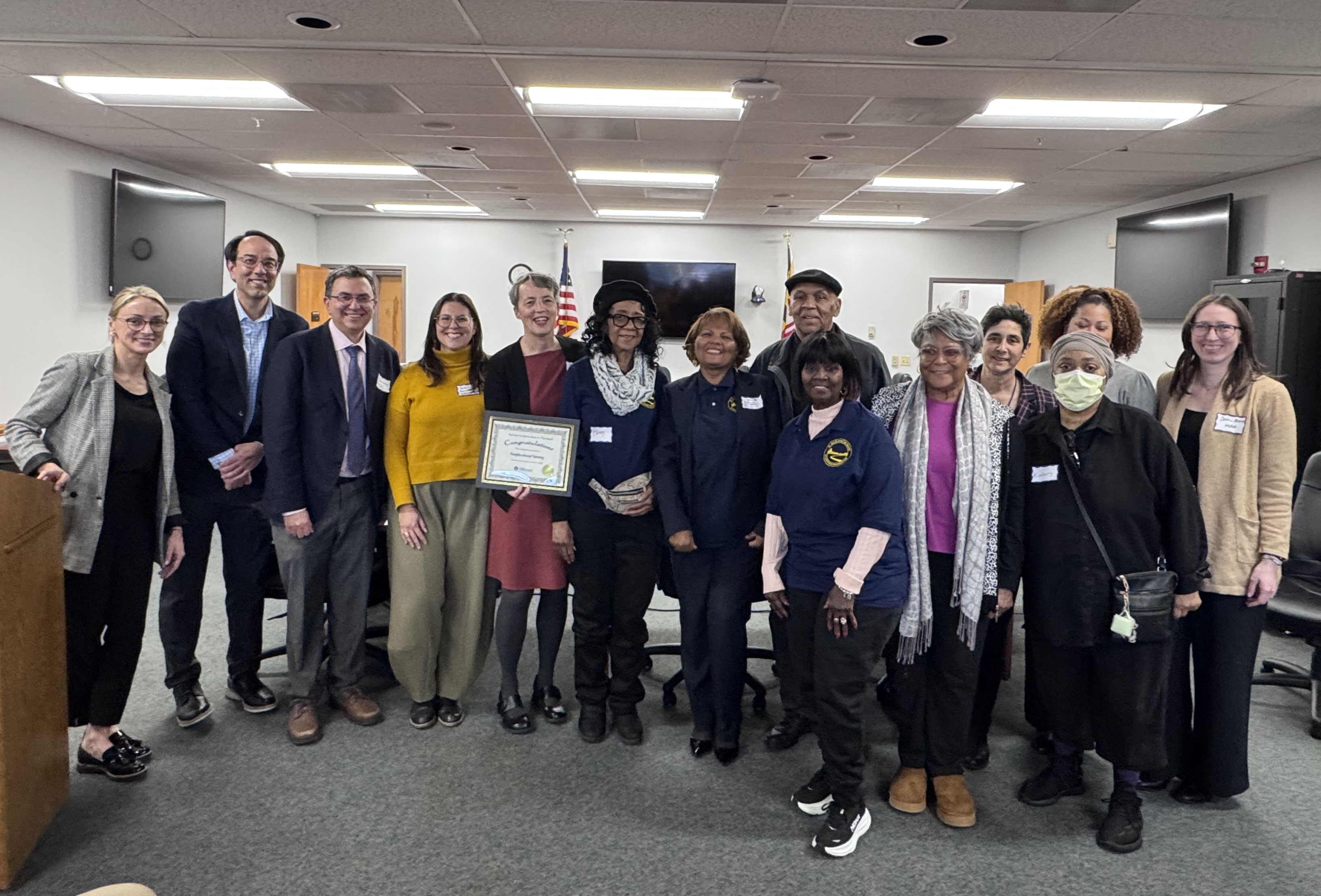 Neighborhood Nursing team celebrating AIM Award with officials in group photo.